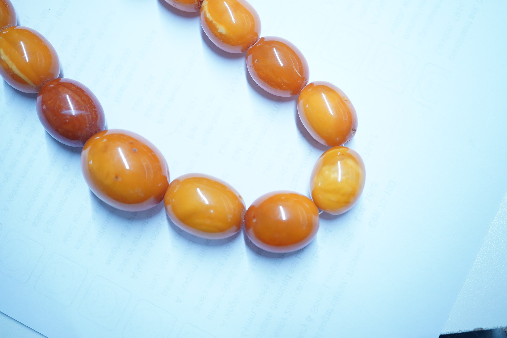 A single strand graduated oval amber bead necklace, 110cm, gross weight 103 grams. Condition - poor to fair